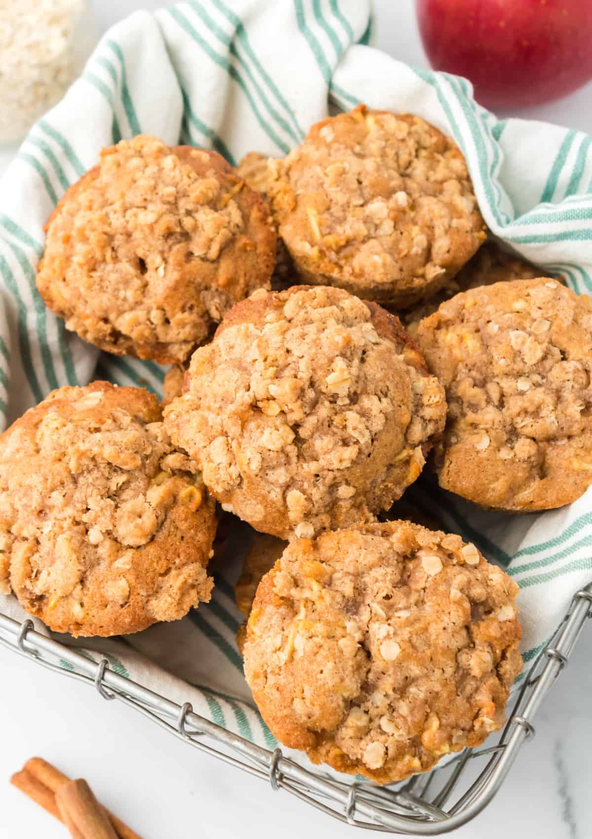 A pile of apple cinnamon muffins in a basket.