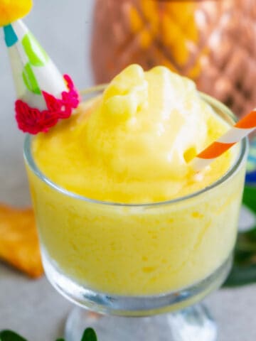 Close up shot of pineapple dole whip in a glass.