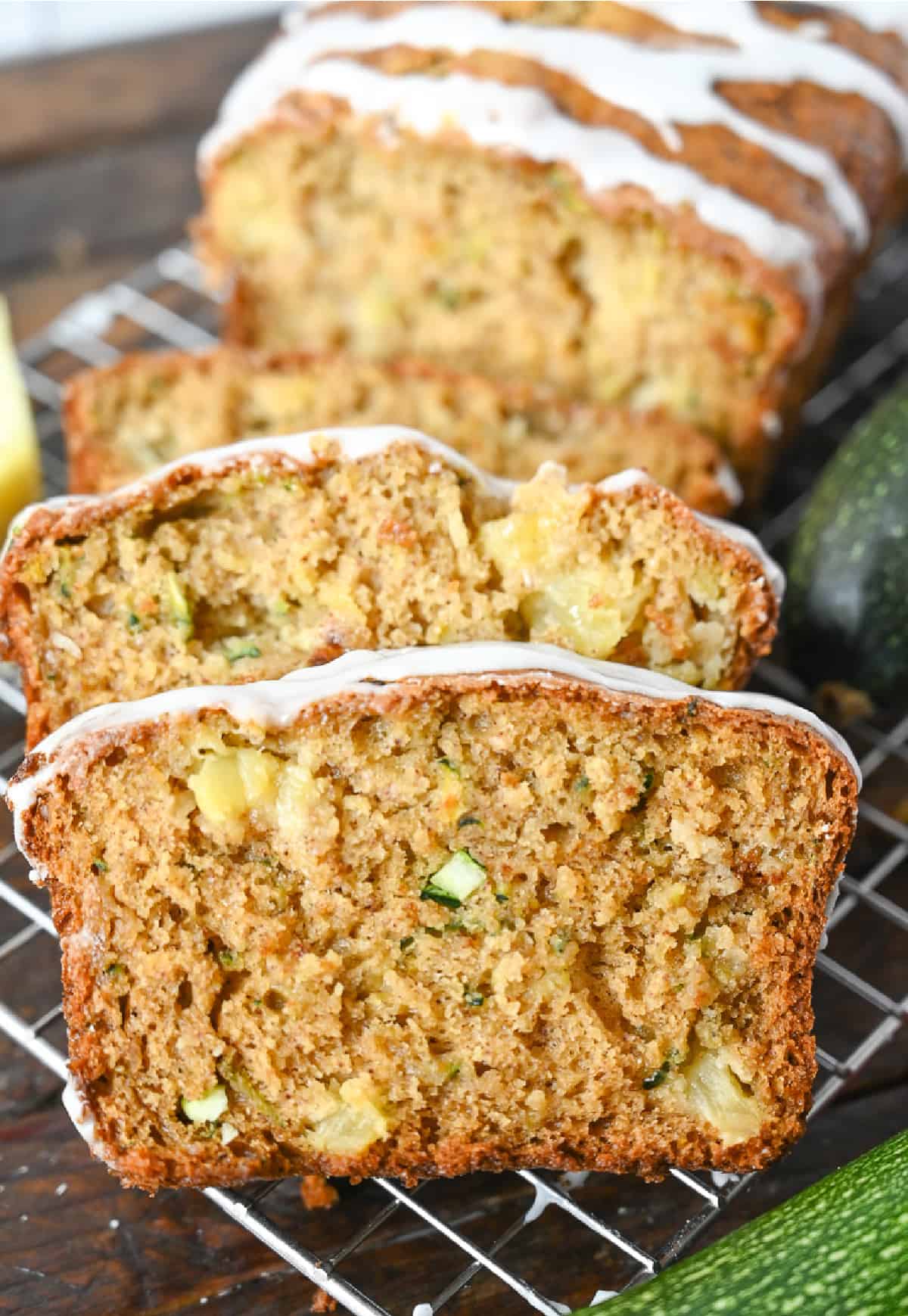 Close up photo of sliced pineapple zucchini bread on a wire cooling rack.