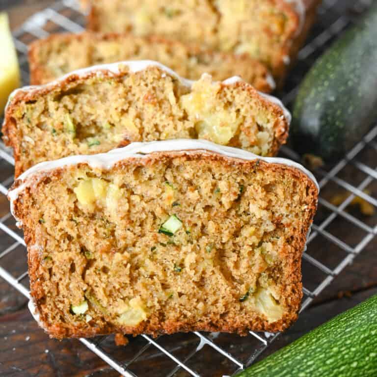 A close up photo of pineapple zucchini bread sliced on a wire cooling rack.