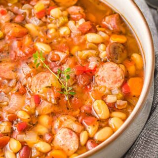 A close up photo of slow cooker sausage bean soup in a bowl.