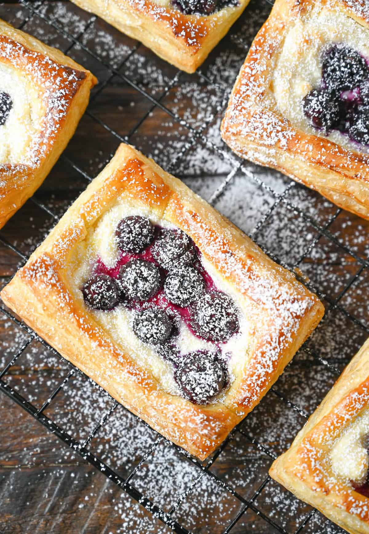 A blueberry cream cheese danish on a wire cooling rack.