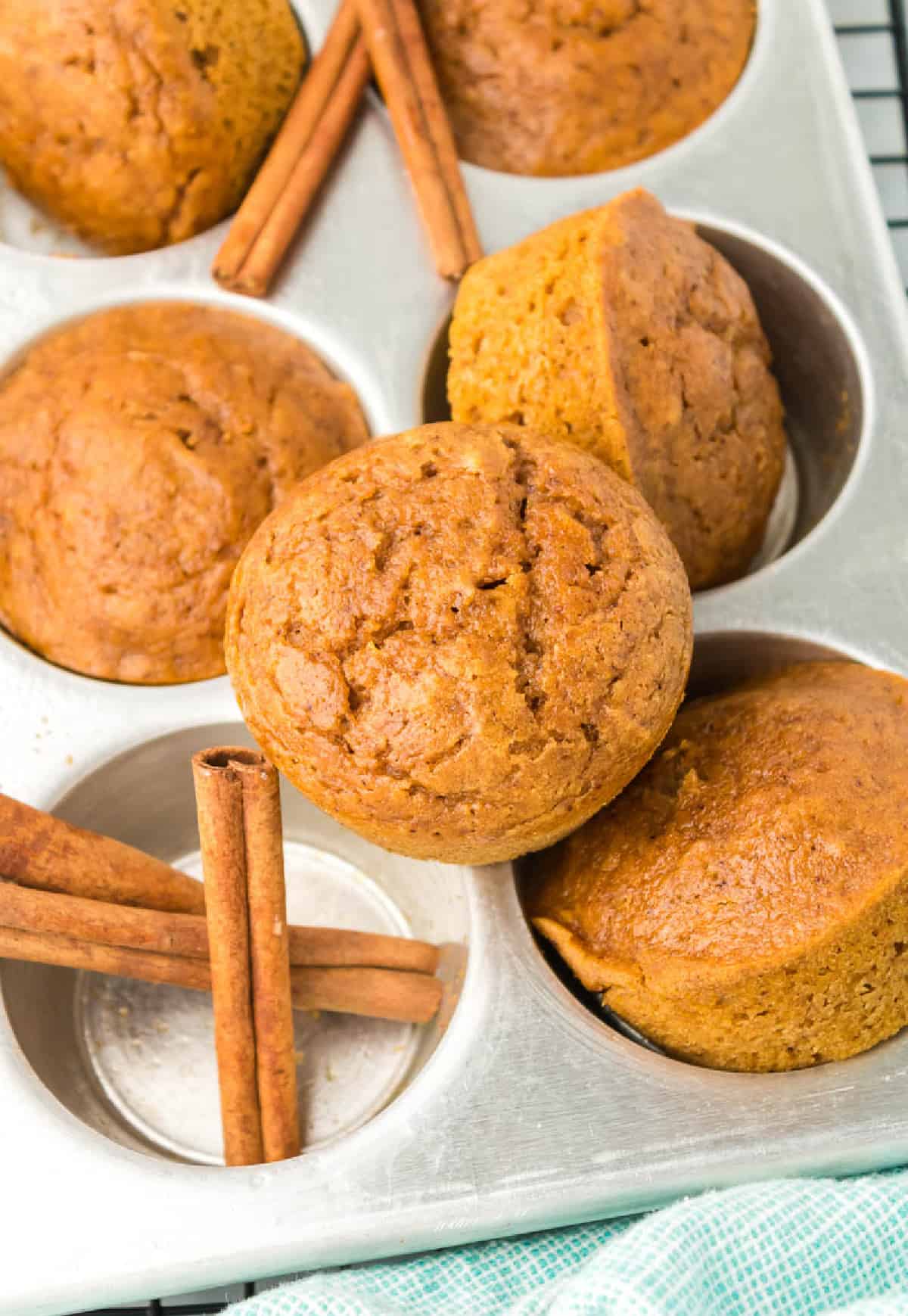 Pumpkin muffin stacked on top of the muffin tin