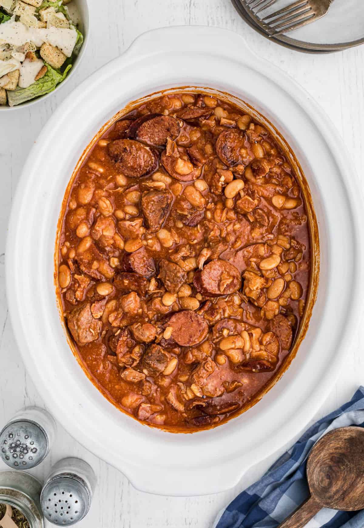 A slow cooker with whitre bean stew in it.