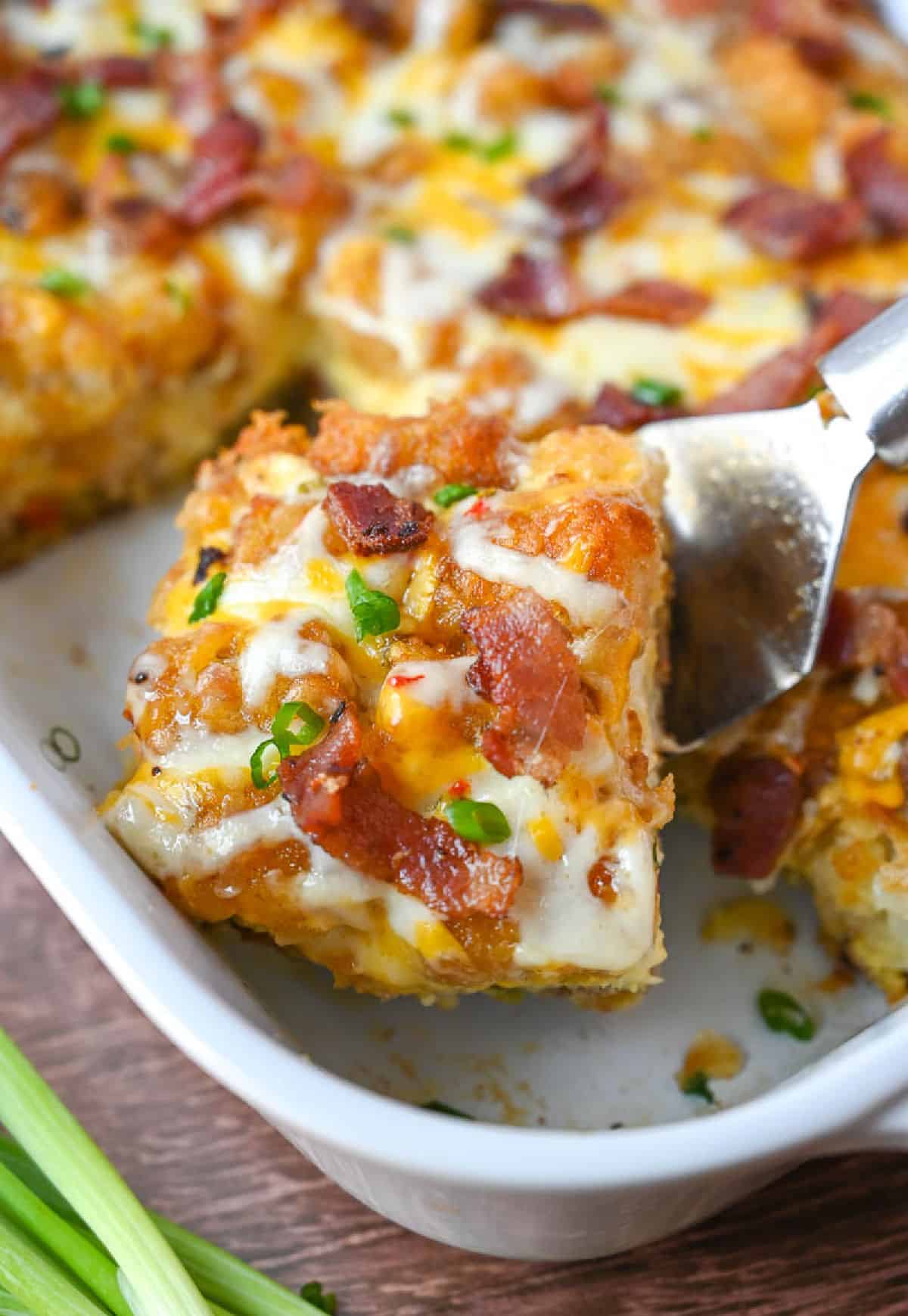 A spatula picking up a square of tator tot breakfast casserole.