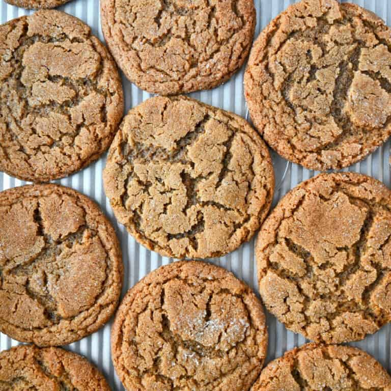 Several ginger snap cookies laying on a baking sheet.