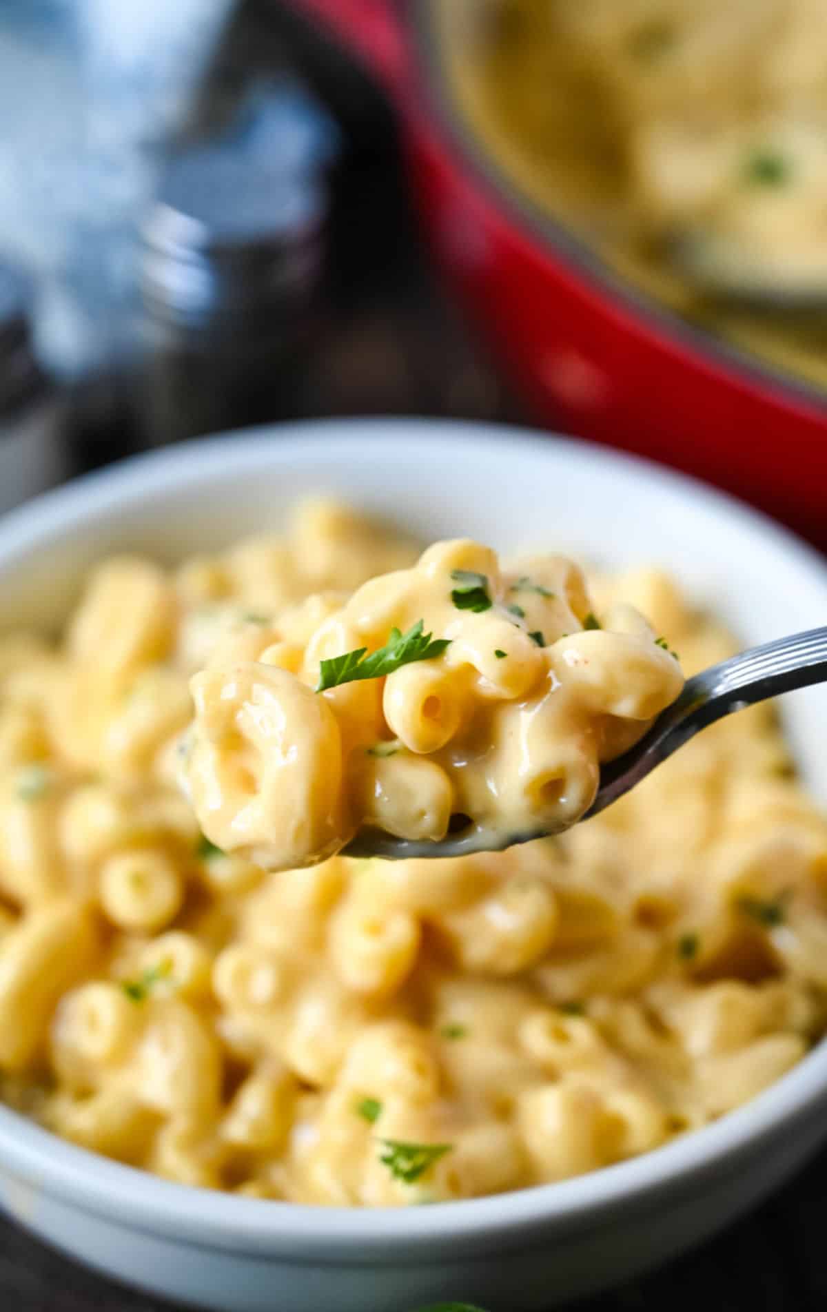 A spoon scooping a bite of stovetop macaroni and cheese.