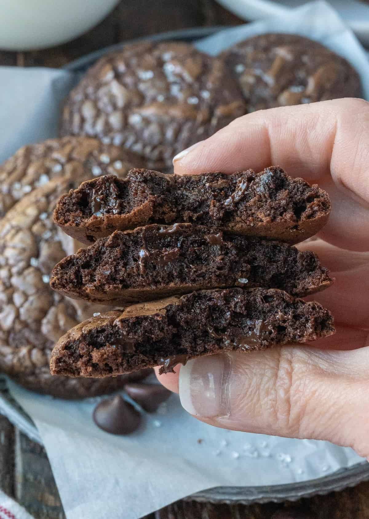 Brownie cookies broken in half and held.