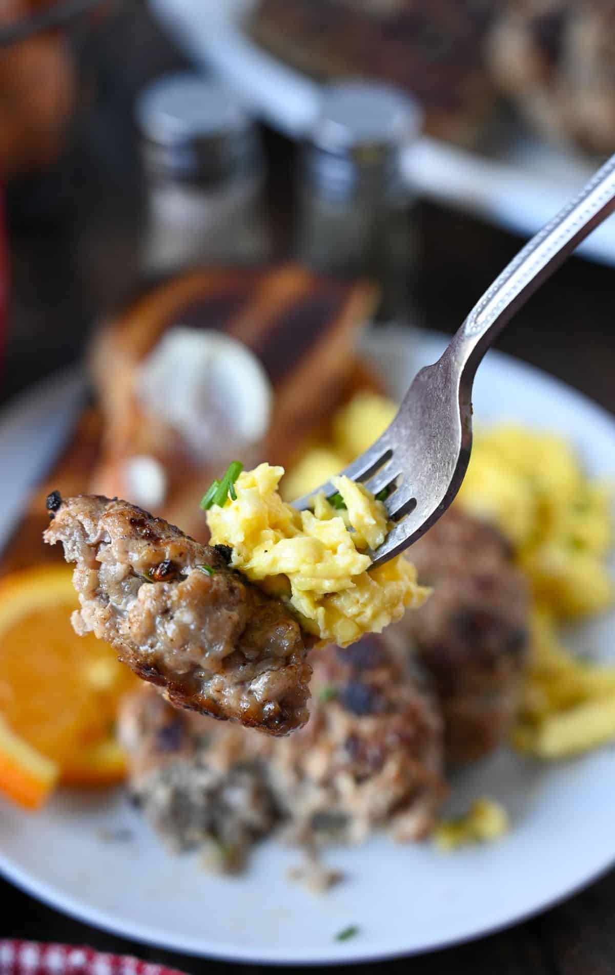 A bite od sausage and eggs on a fork.