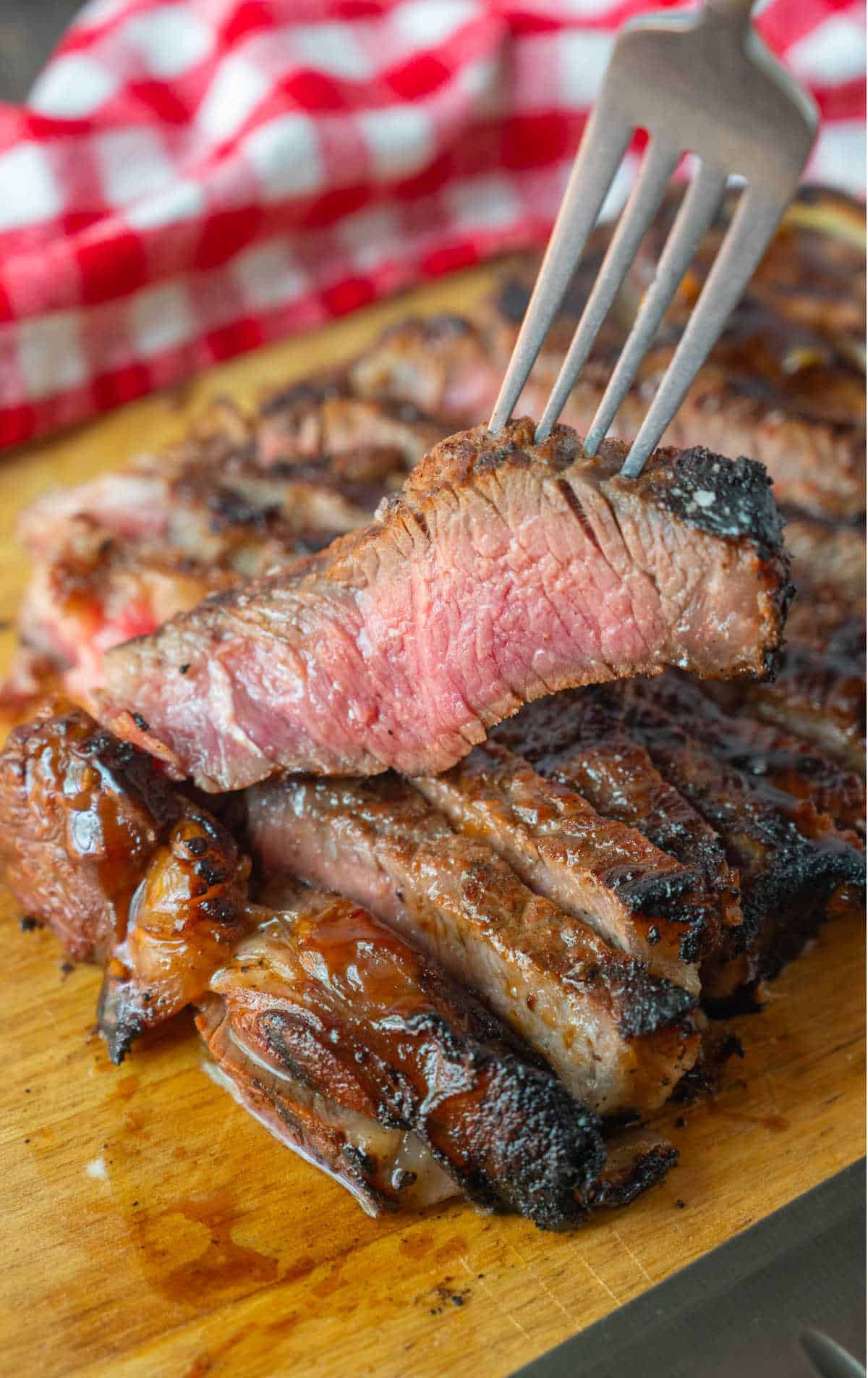 A fork picking up a slice from the cutting board.