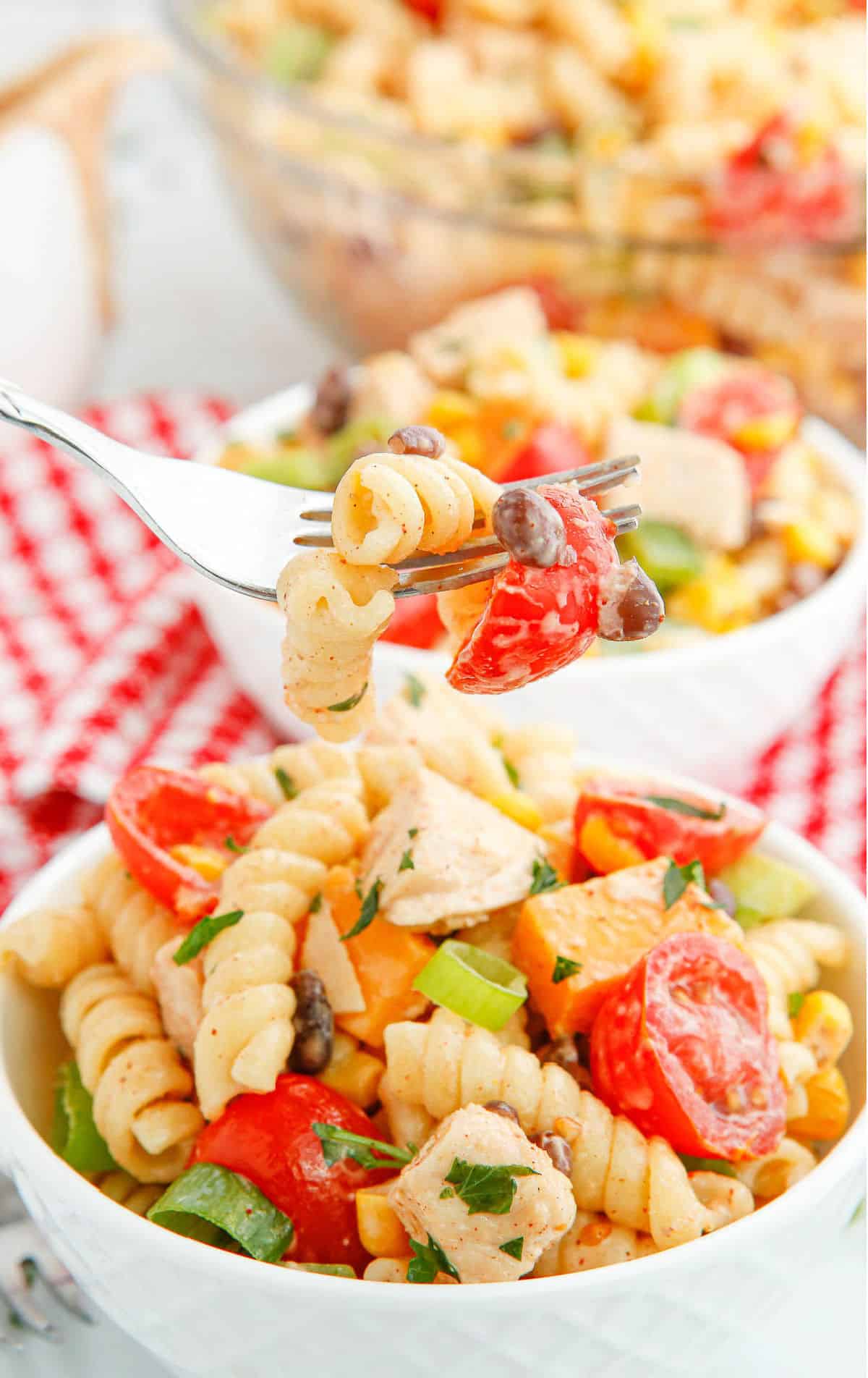 A serving of pasta salad in a bowl with a fork.