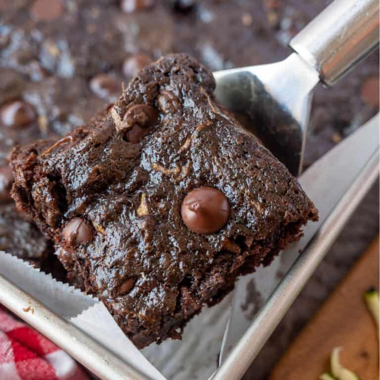 A metal spatula holding a zucchini brownie.