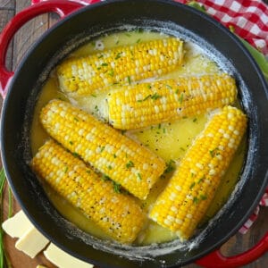 Corn cobs in a pot with milk, butter and water.