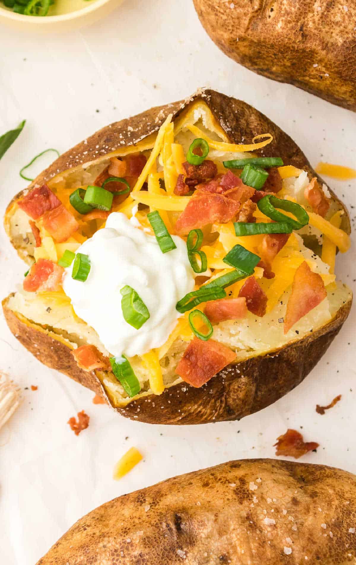 A baked potato loaded with butter, cheese, sour cream and bacon.