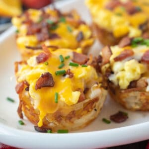 Scrambled egg hash brown cups on a white plate.