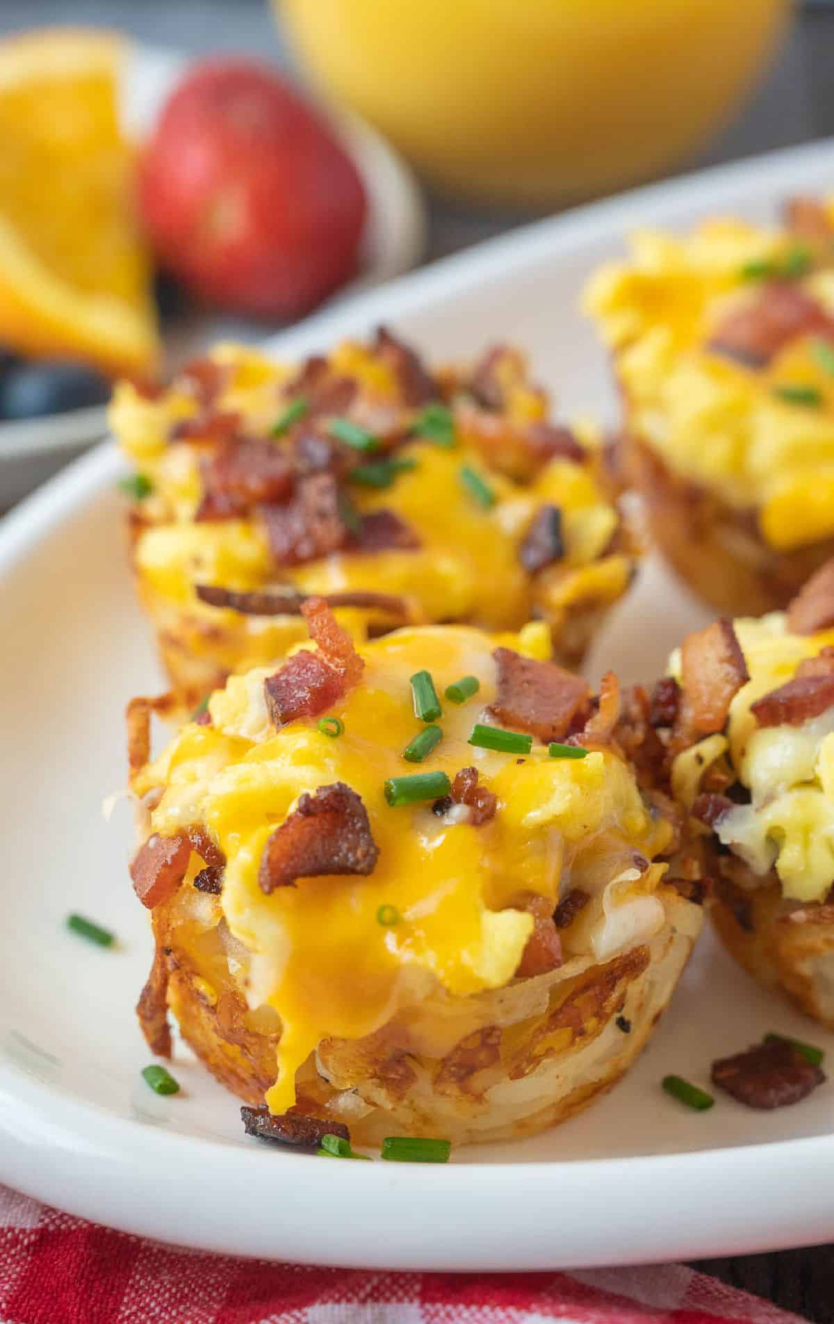 Scrambled egg hash brown cups on a white plate.