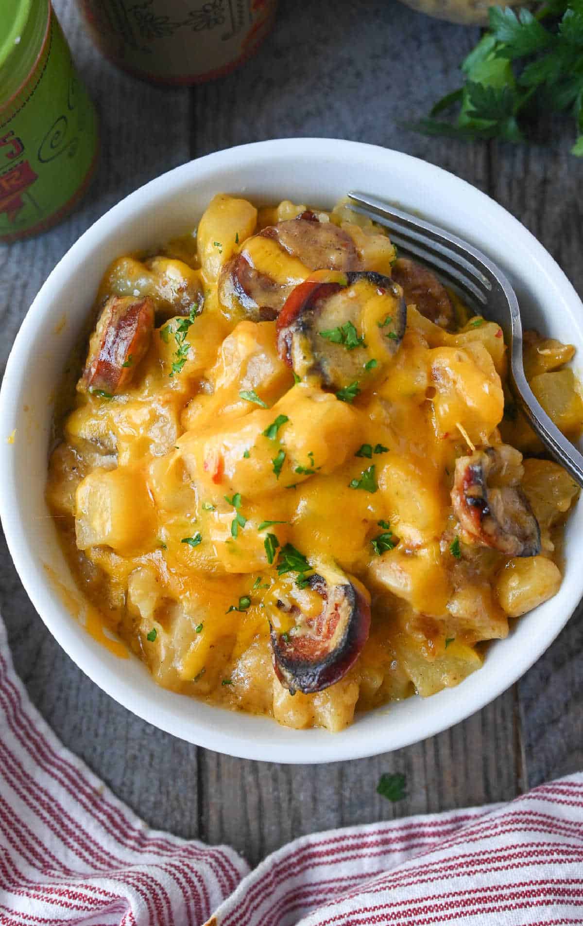 A bowl of cheesy potatoes with sausage.