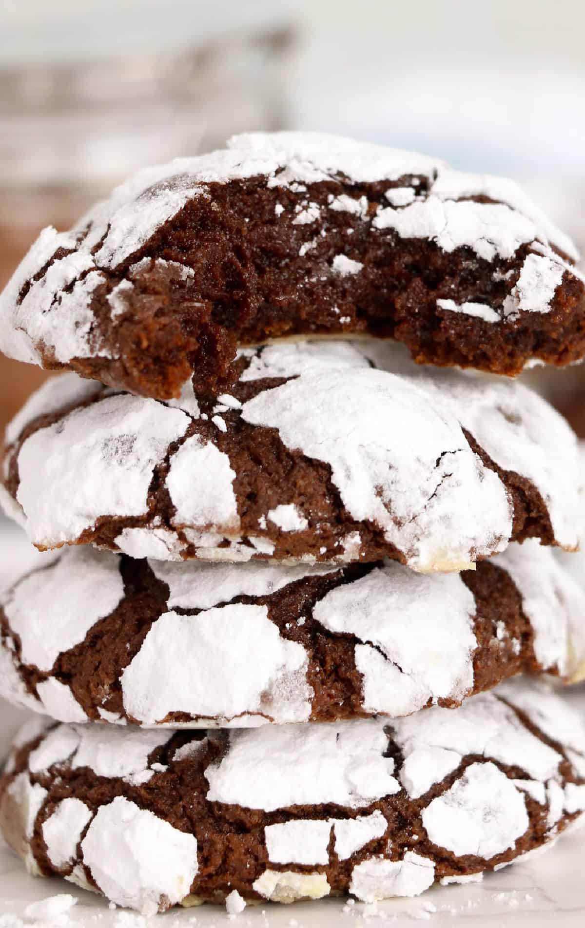 A stack of chocolate cookies with the one on top with a bite out.