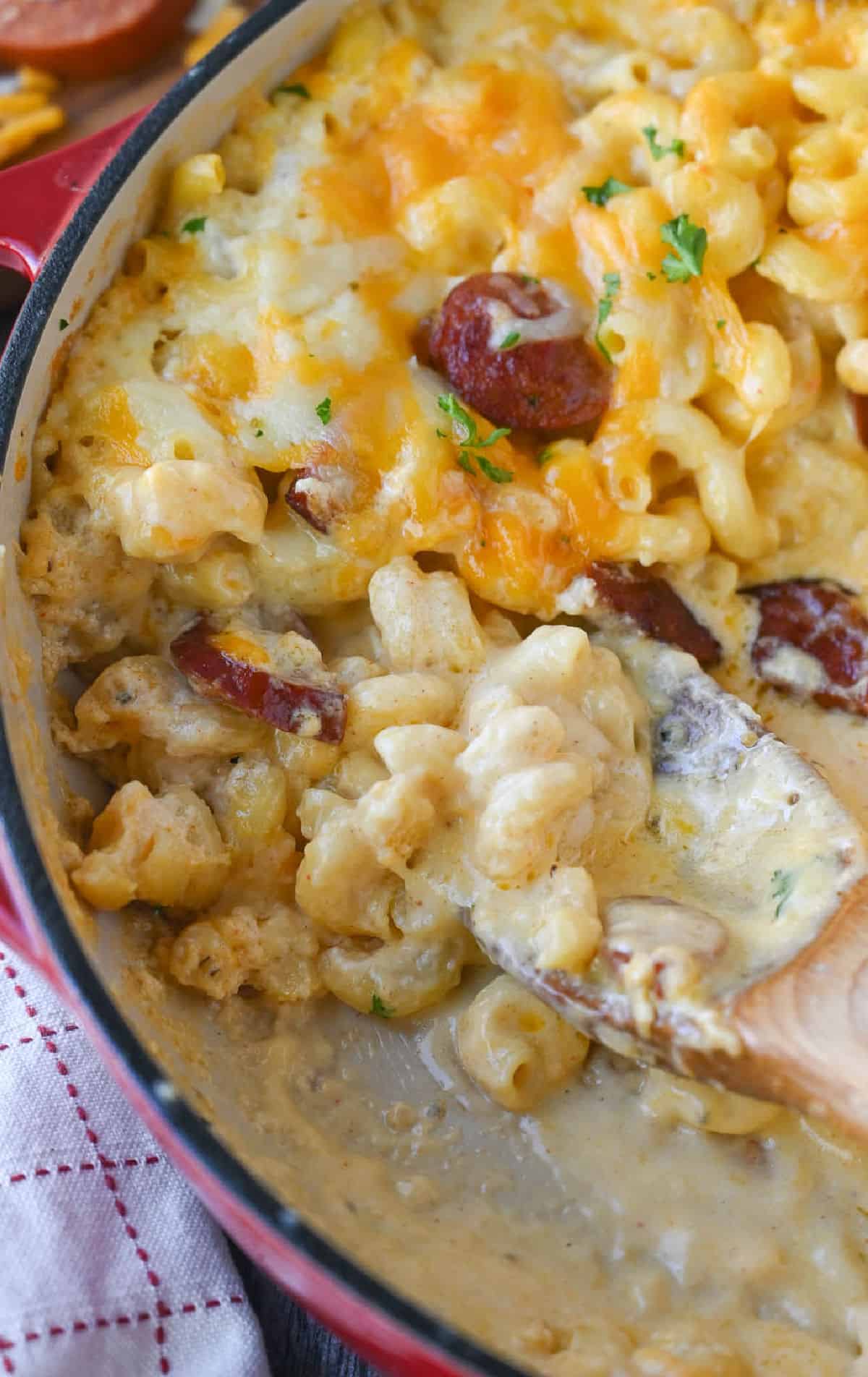 A spoon placed into a skillet with mac n cheese.