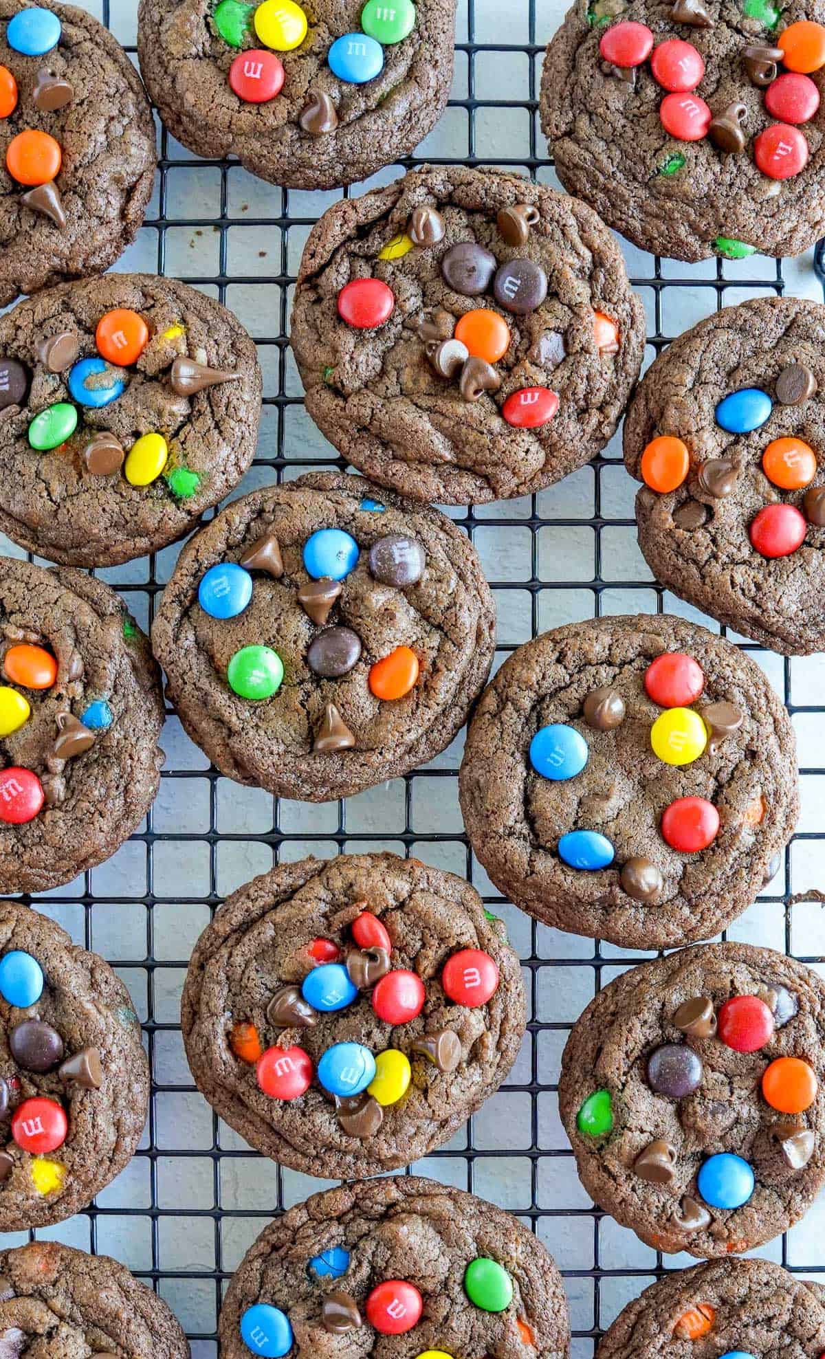 Triple chocolate M&M cookies on a cooling rack.