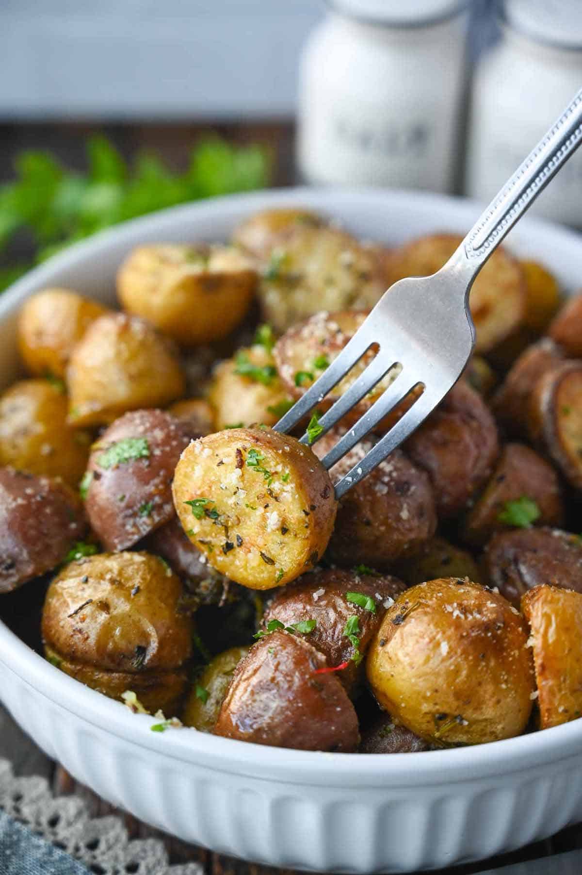 A fork picking up a baby potato.