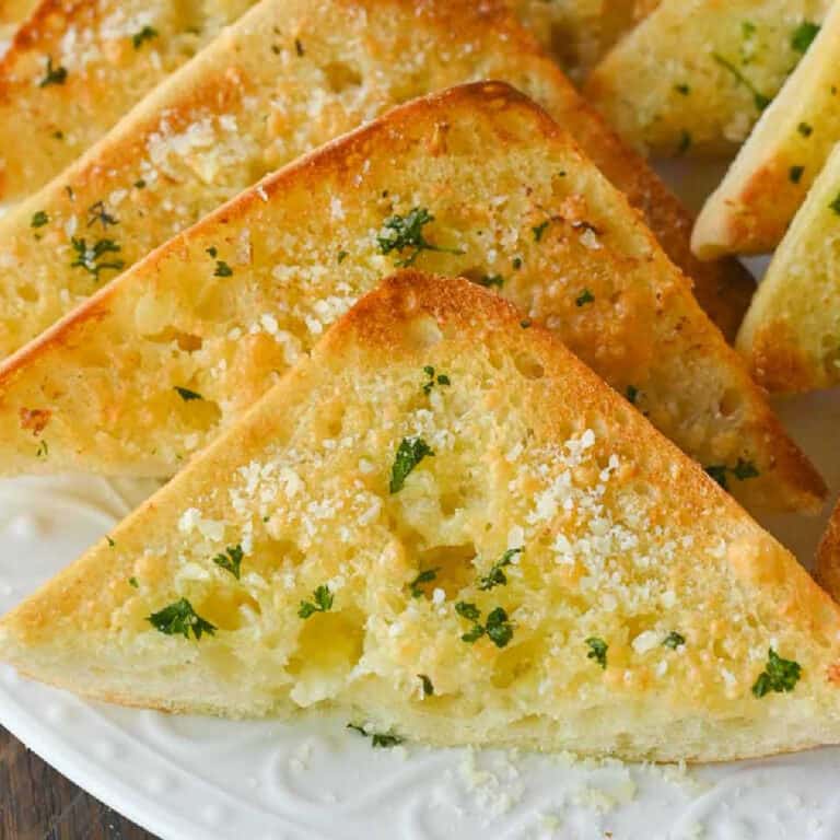 Garlic bread slices on a white plate.