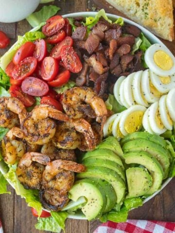 Grilled shrimp cobb salad placed in a large white bowl.