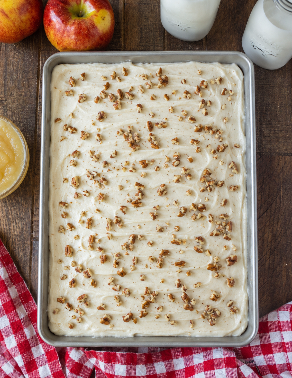 Applesauce cake with cream cheese frosting and pecans on top.