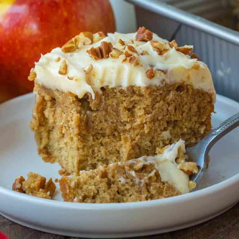 A slice of cake on a plate with a fork taking a bite out of it.