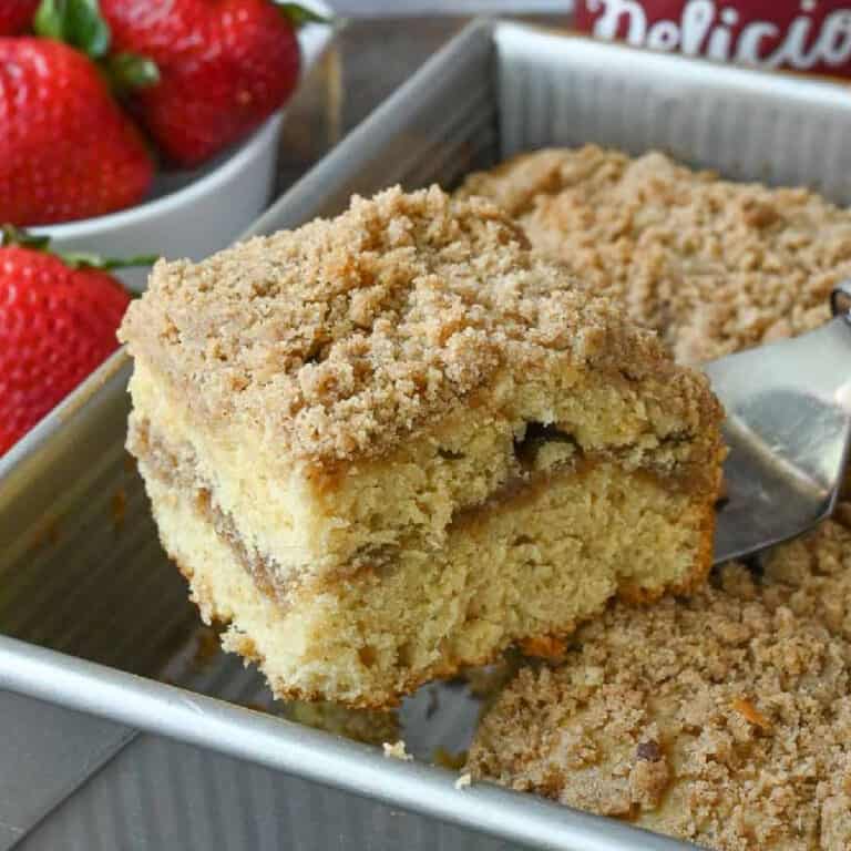 A spatula picking up a slice of sour cream crumb cake.