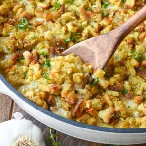 Chicken stuffing casserole with a wooden spoon scooping some out.