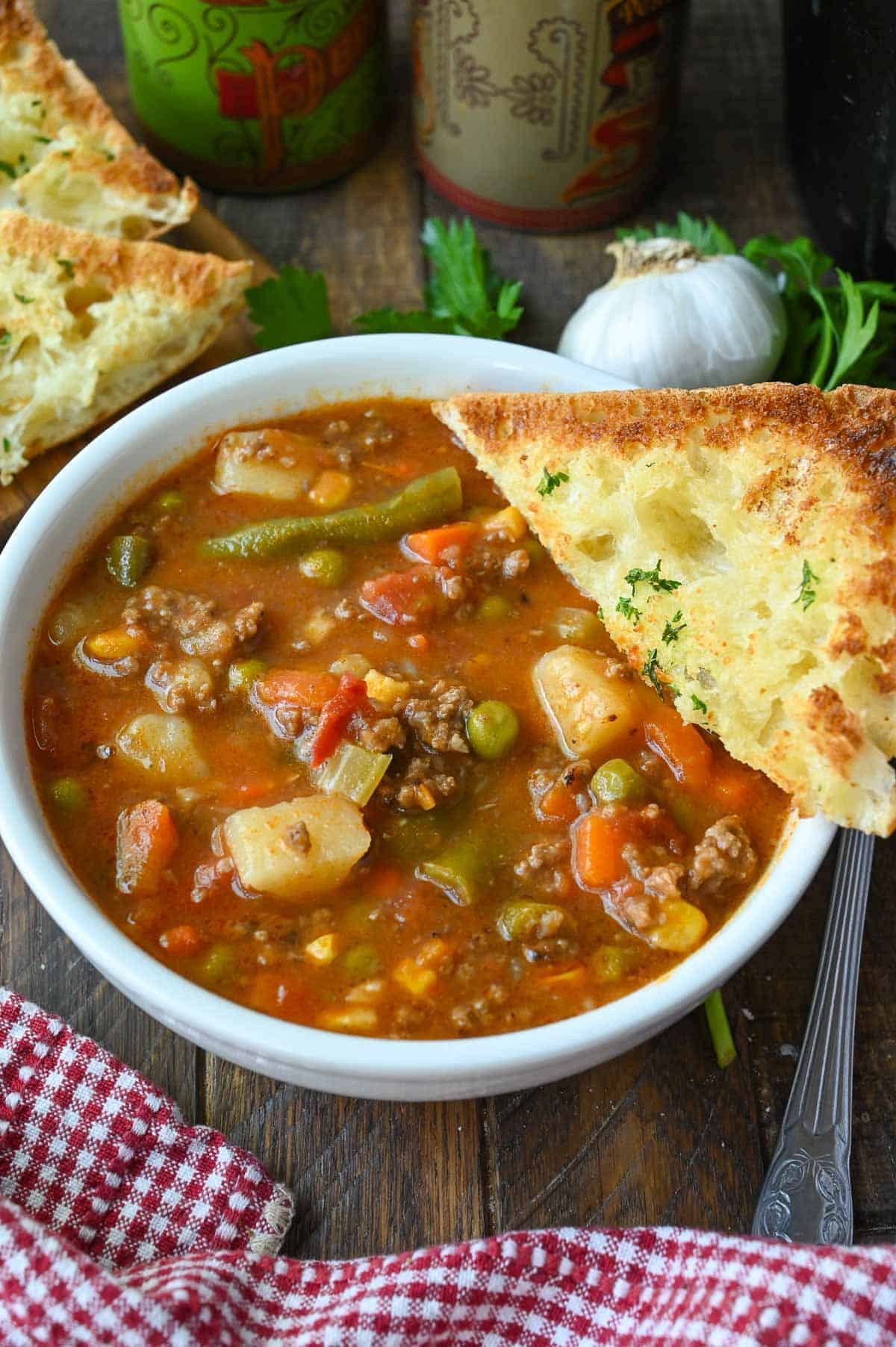 Hamburger stew in a bowl with crusty bread.