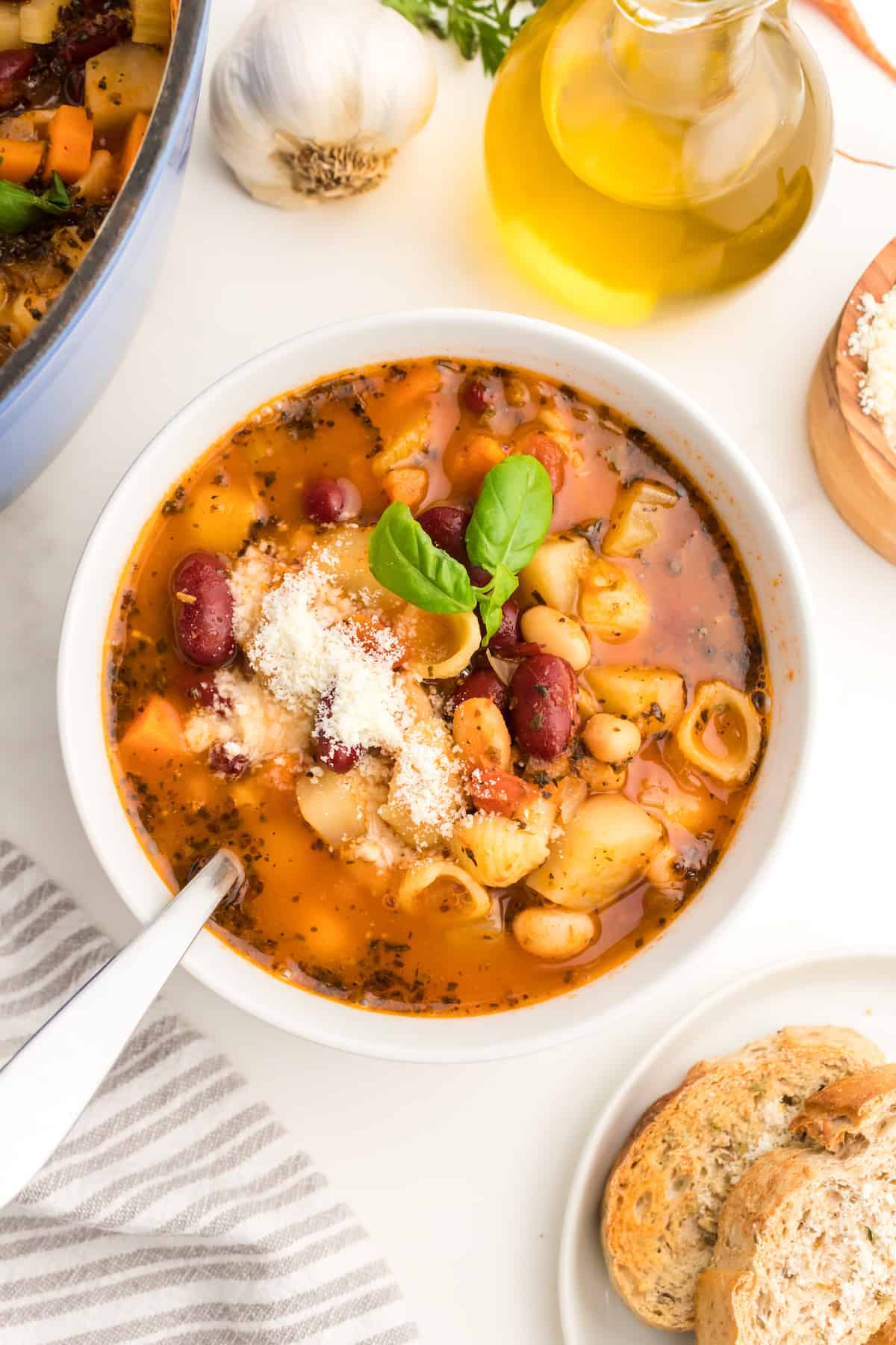 Minestrone soup in a bowl with parmesan cheese on top.