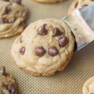 A close up of a spatula lifting a chocolate chip cookie.