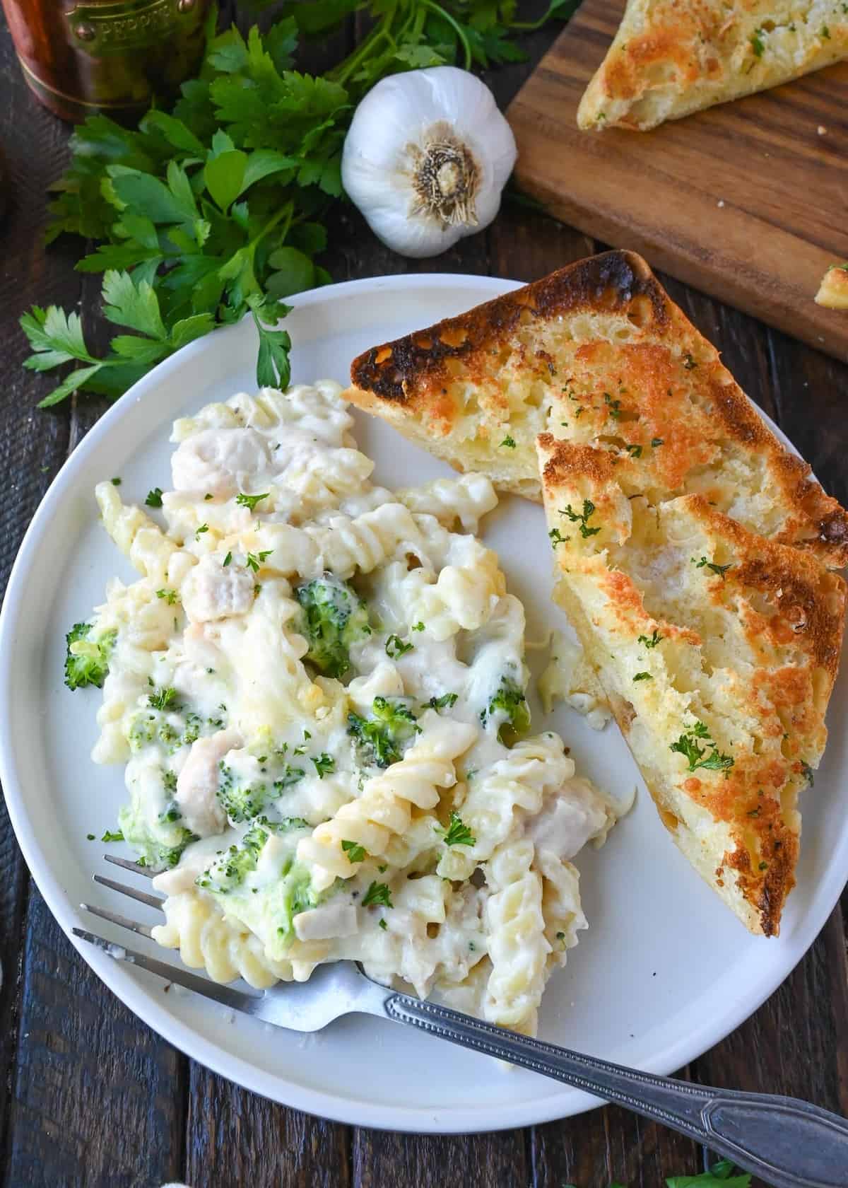 Chicken and broccoli alfredo bake on a plate with ciabatta garlic bread.