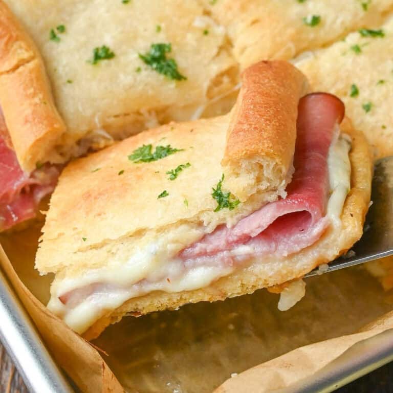 Hot ham and cheese sandwich being picked up with a spatula.