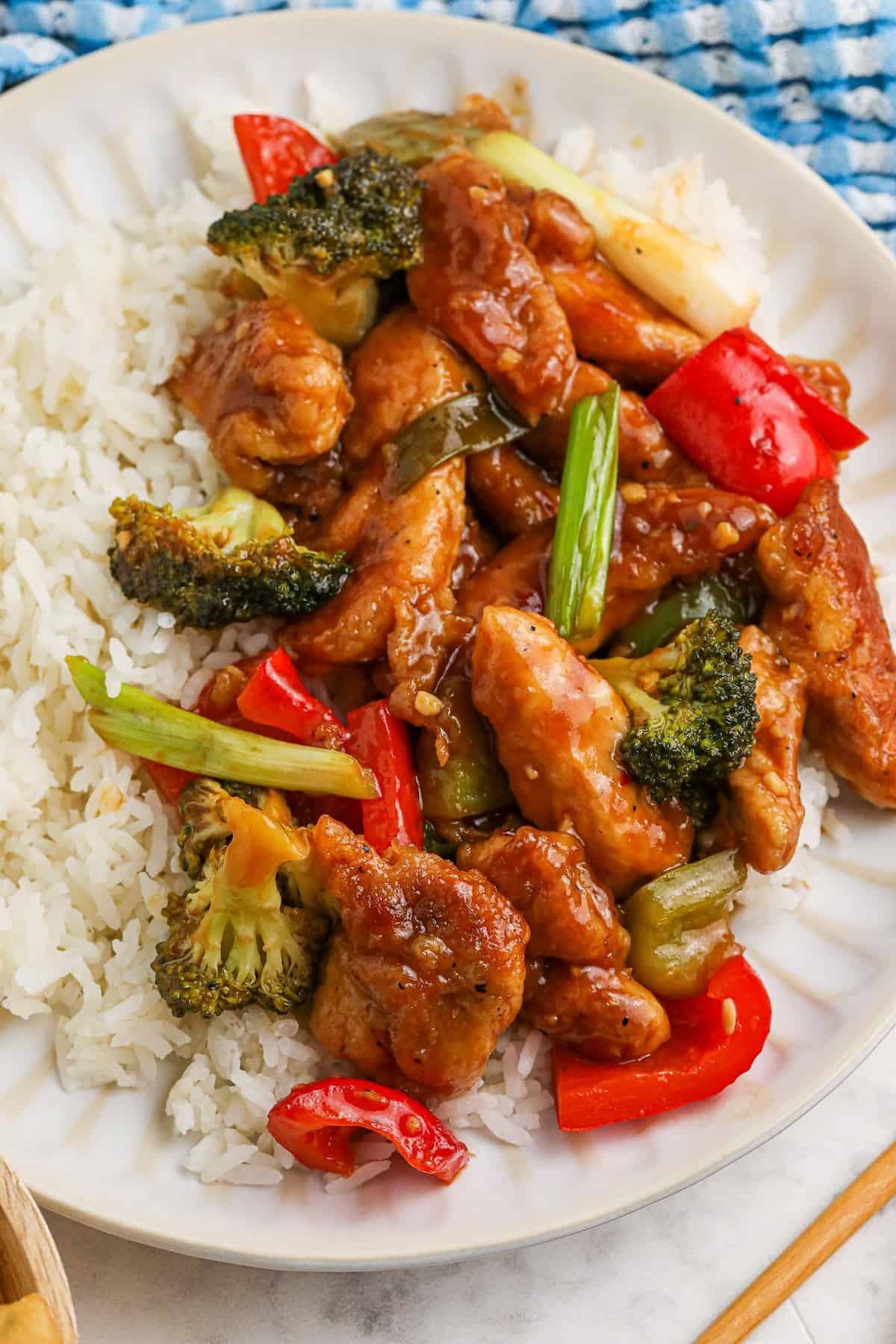 Spicy hunan chicken served on a plate with rice.