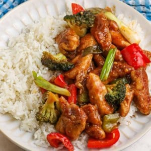 Close up of spicy hunan chicken on a plate with rice.