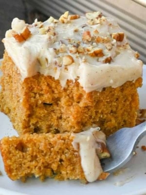 A piece of sweet potato cake on a place with a bite on a fork.