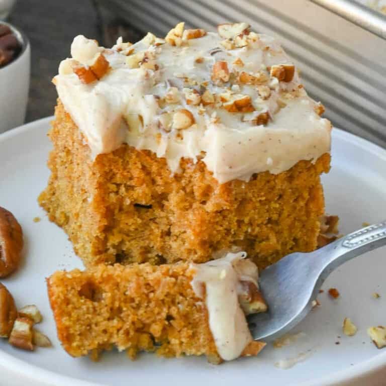 A piece of sweet potato cake on a place with a bite on a fork.