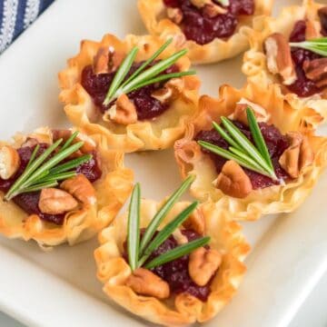 Cranberry brie bites on a white platter.