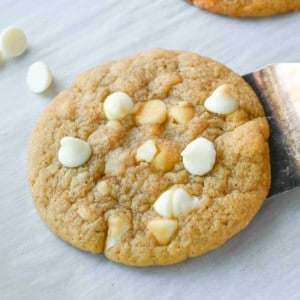 A close up of a golden brown white chocolate macadamia nut cookie.