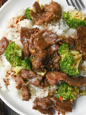 Close up of beef and broccoli on top of white rice.