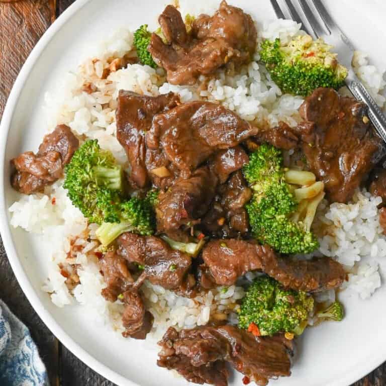 Close up of beef and broccoli on top of white rice.
