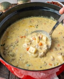 A ladle scooping up some cheese burger soup.