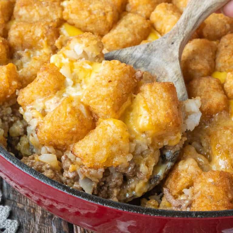 A wooden spoon scooping out some big mac casserole.