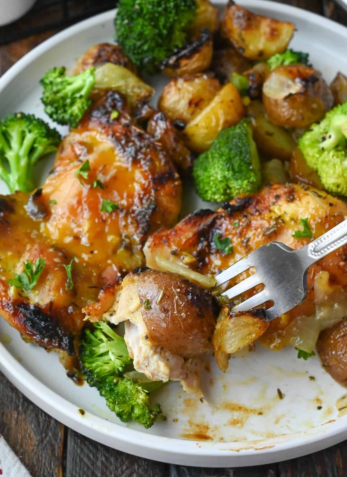 A fork taking a bite of chicken and broccoli.