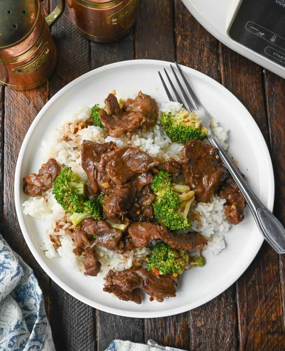 Close up of beef and broccoli on top of white rice.
