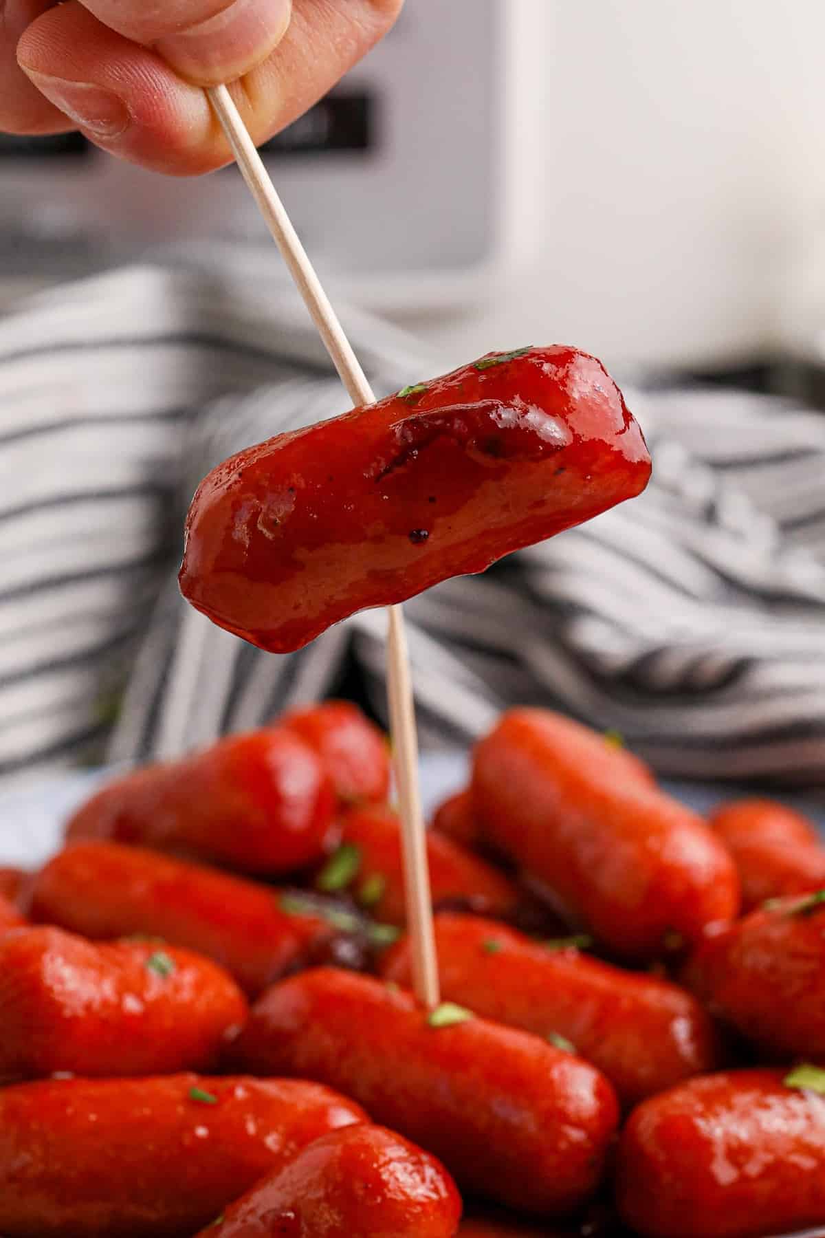 Picking up a slow cooker cranberry smoky with a skewer.