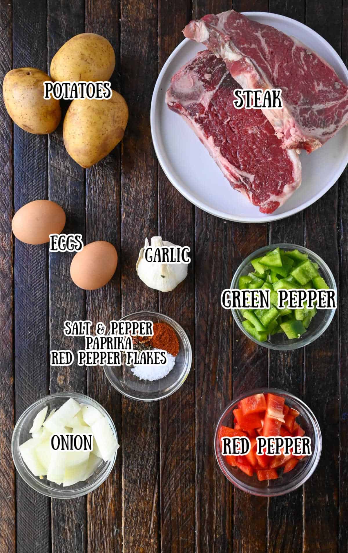 Labelled ingredients for steak and potato breakfast hash on a dark wooden countertop.